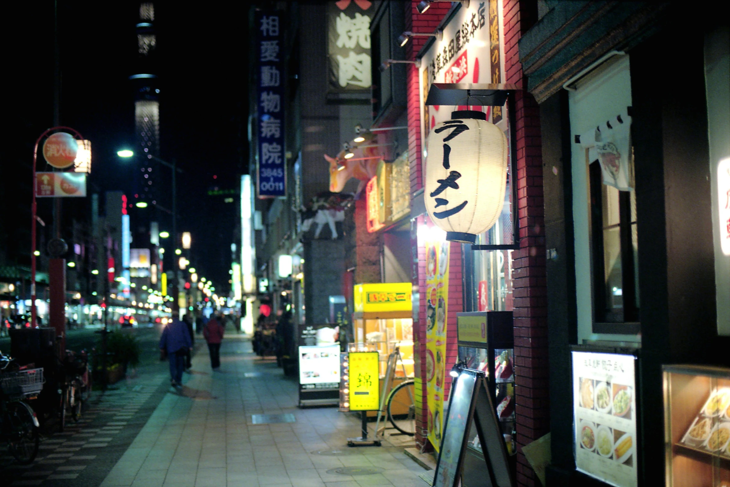 this is a night time po of people walking down the street