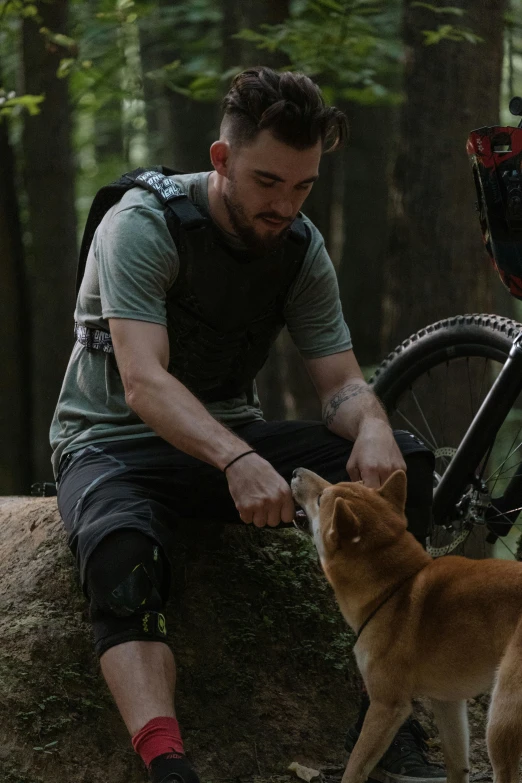 the man is tying his shoe with a small dog