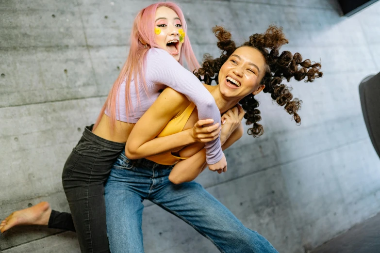 two females dressed in costume dance while one holds her