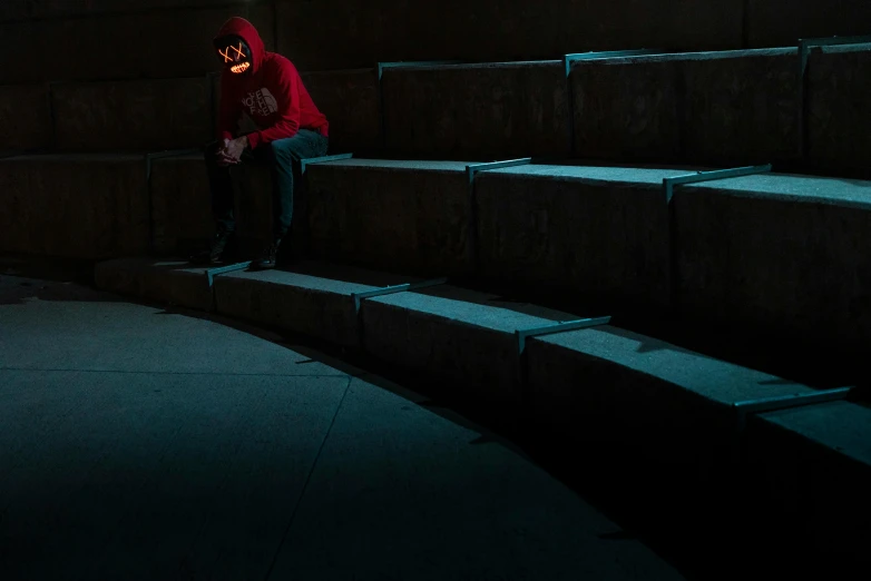 a person in red jacket sitting at some stairs