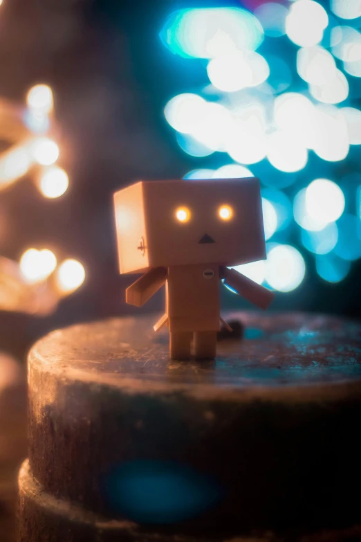 an image of a small robot toy next to a candle