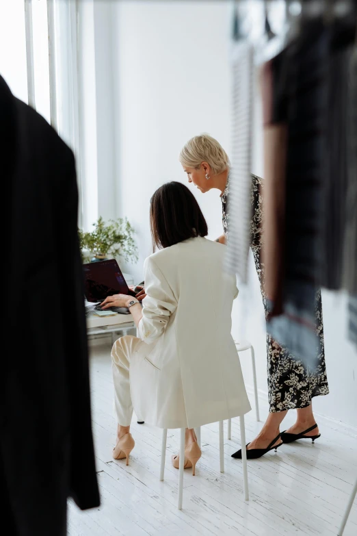 two women in business suits sitting at a desk