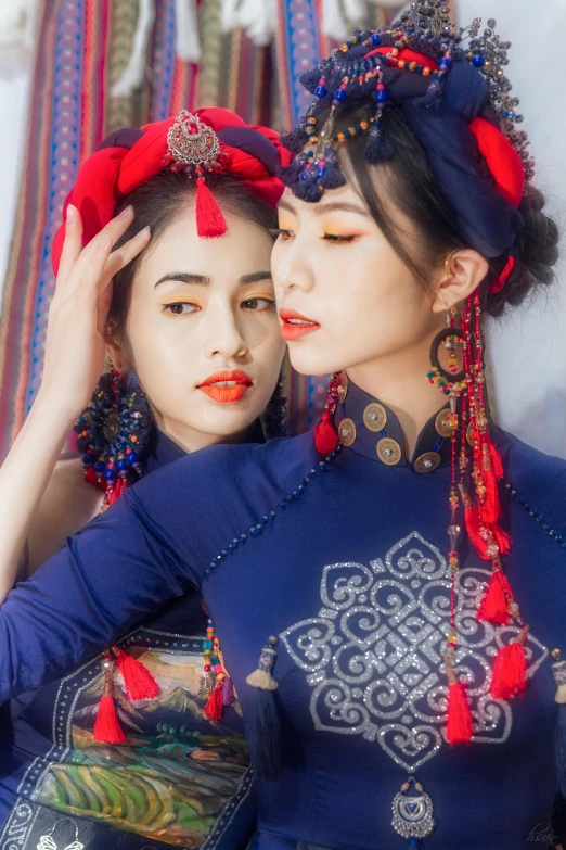 a pair of young women wearing head dresses, standing next to each other