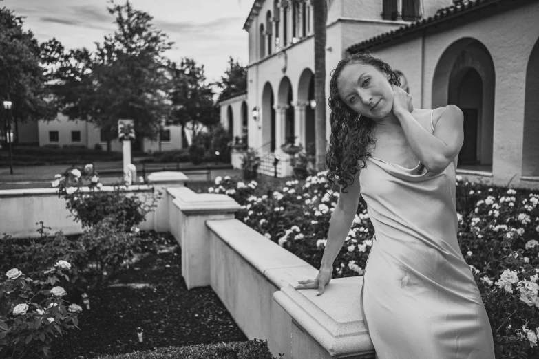 a woman wearing a dress standing on a bench