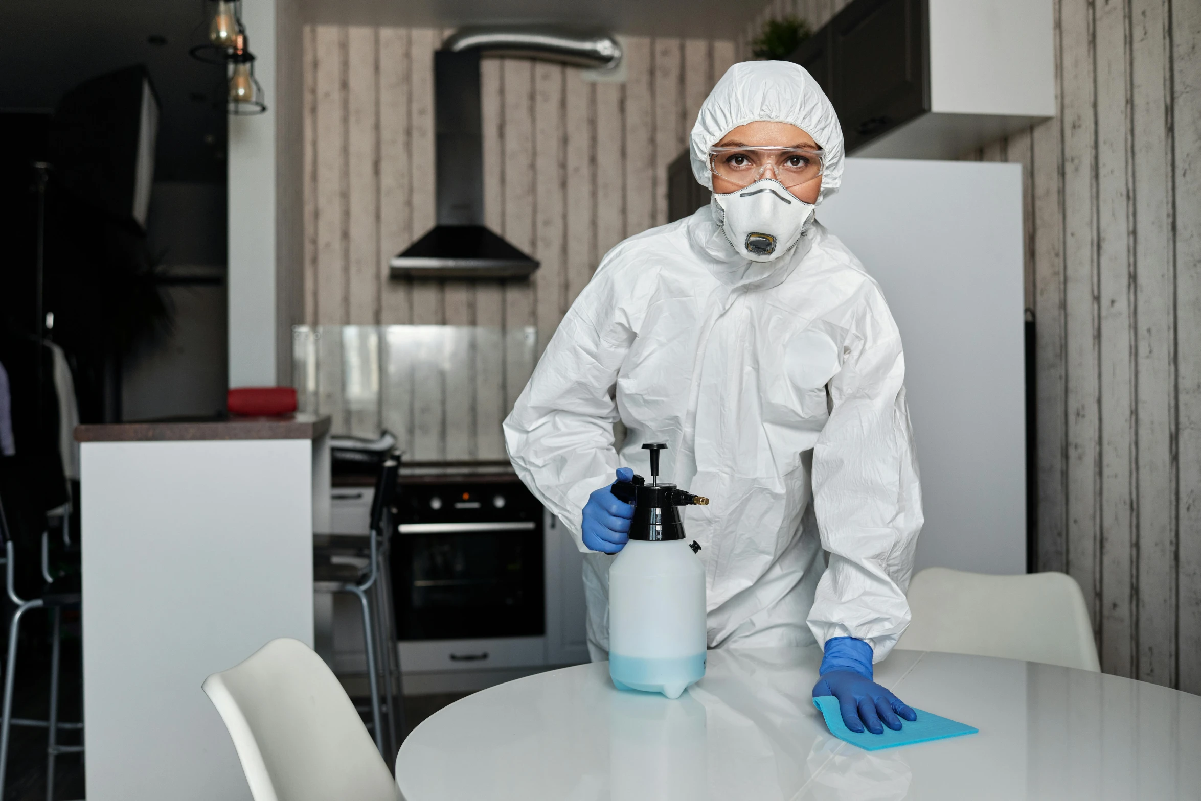 a person wearing white is spray painting a table