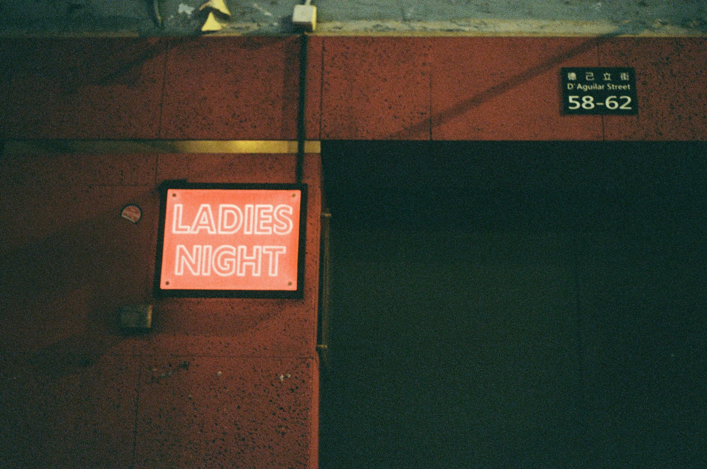 a red sign on the wall stating ladies night