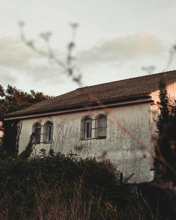 the sun is out behind some trees and a house