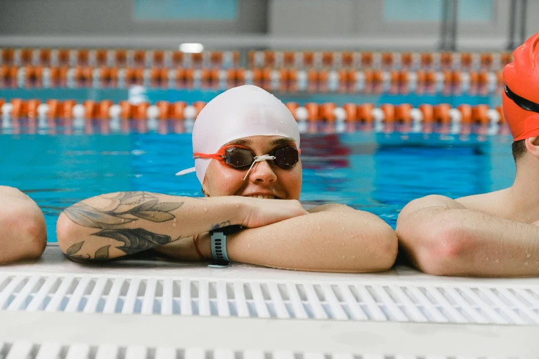 man in swimming pool wearing red caps and swim goggles