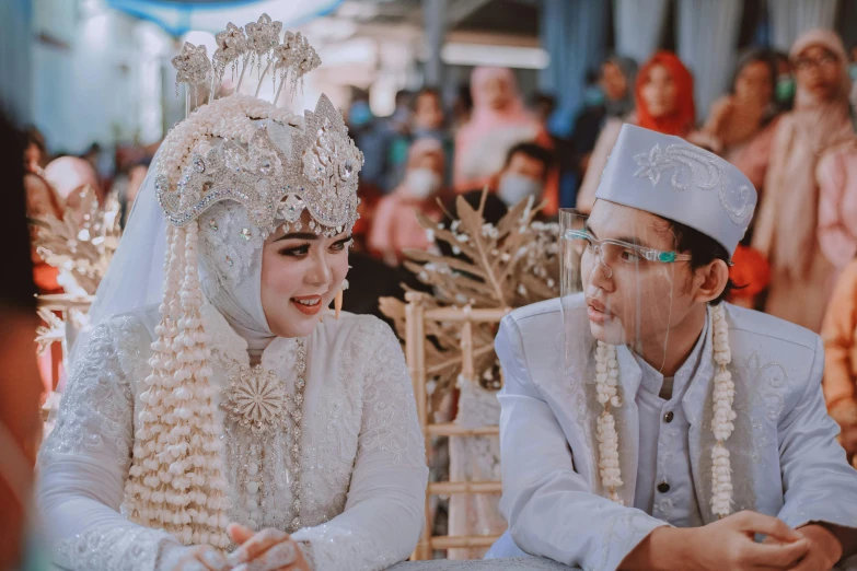 two people in white outfits sitting next to each other