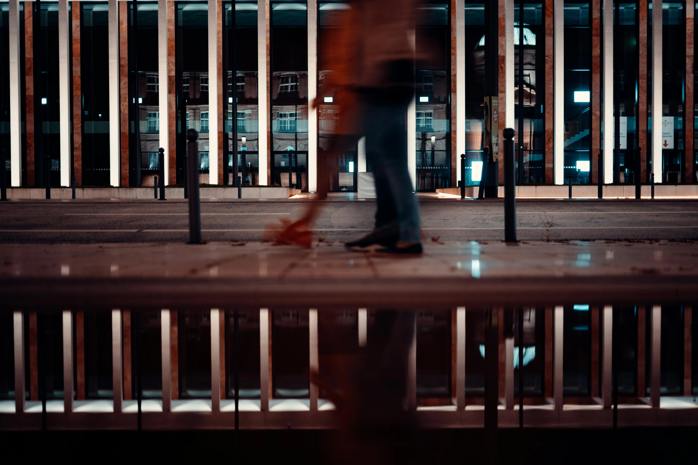 a man is walking down the sidewalk of a building