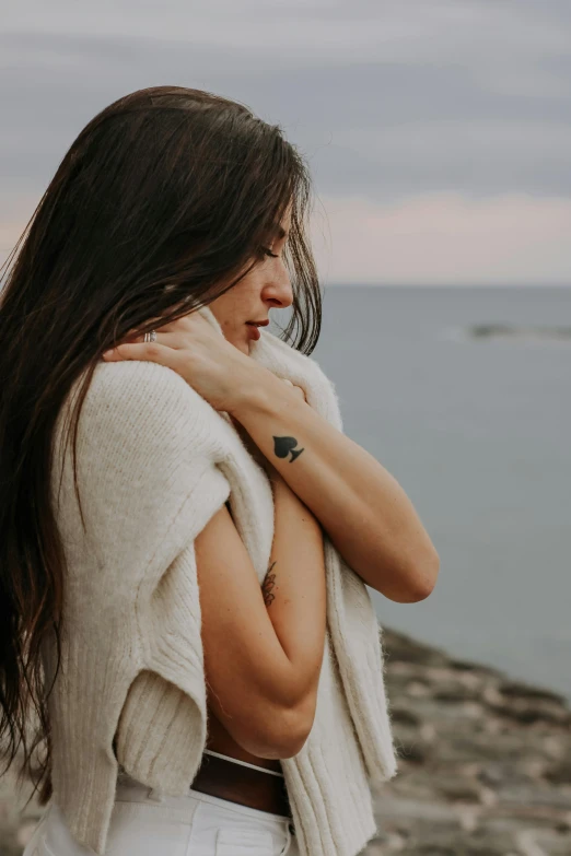 there is a woman that is standing next to the ocean