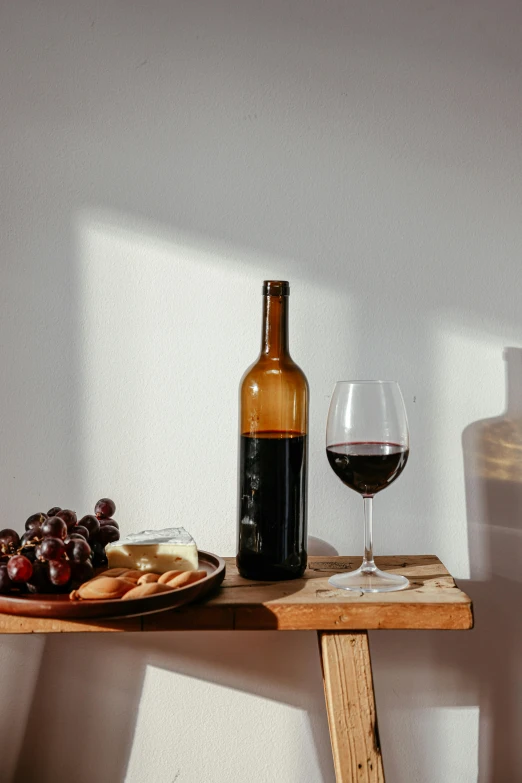 a wine bottle and a glass of wine on a wooden table