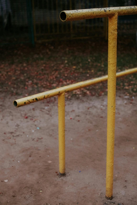 a yellow metal gate on the ground near a fence