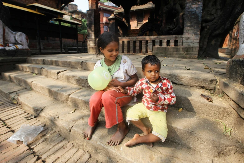 an adult sitting on the stairs of a temple