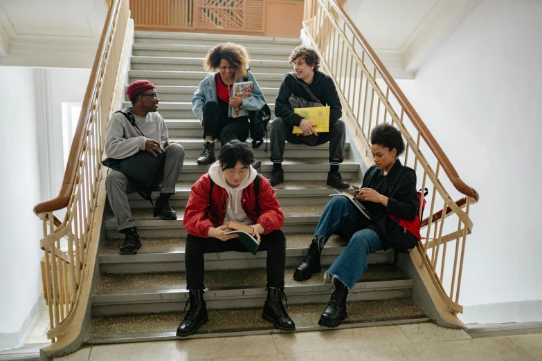 young adults sitting on steps in a public building