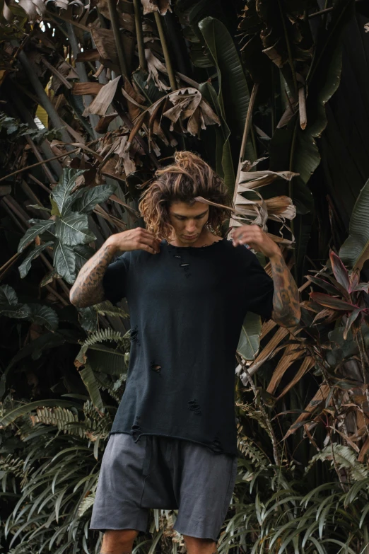 a man standing in front of green plants