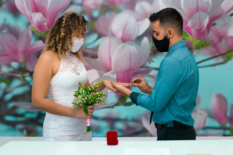 a man and woman exchanging wedding vows in front of a wall