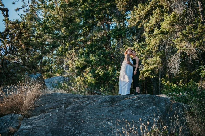 a couple standing in a forest holding each other's eyes