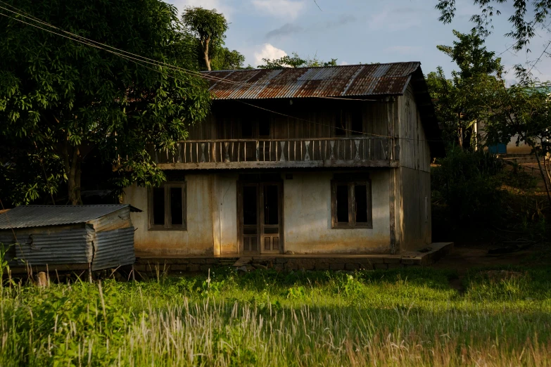 a small, rustic looking old house that's in an overgrown field