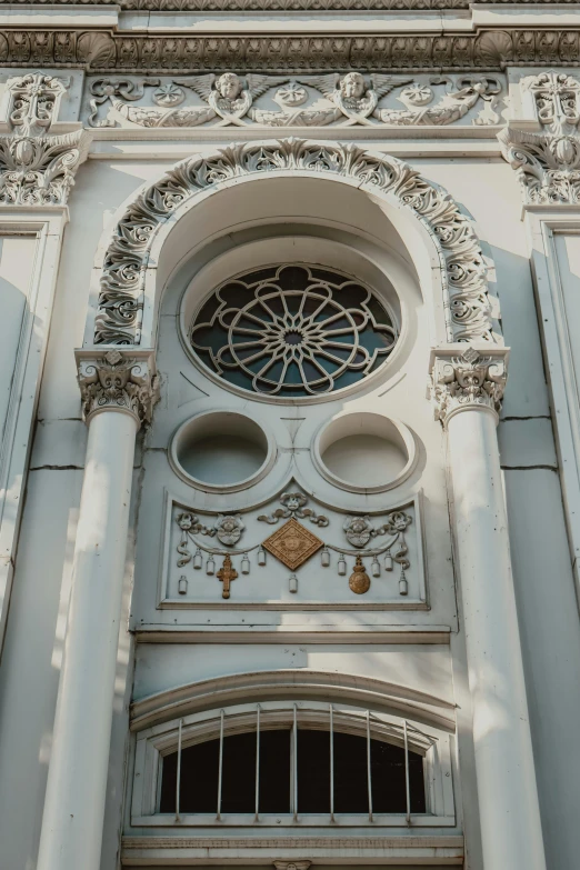 a building with white stucco and an intricate stone work above the window