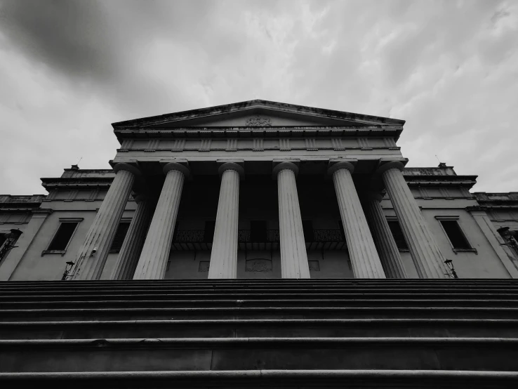 the front view of a large building with pillars and pillars