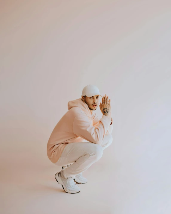 a man kneeling down wearing a pink jacket