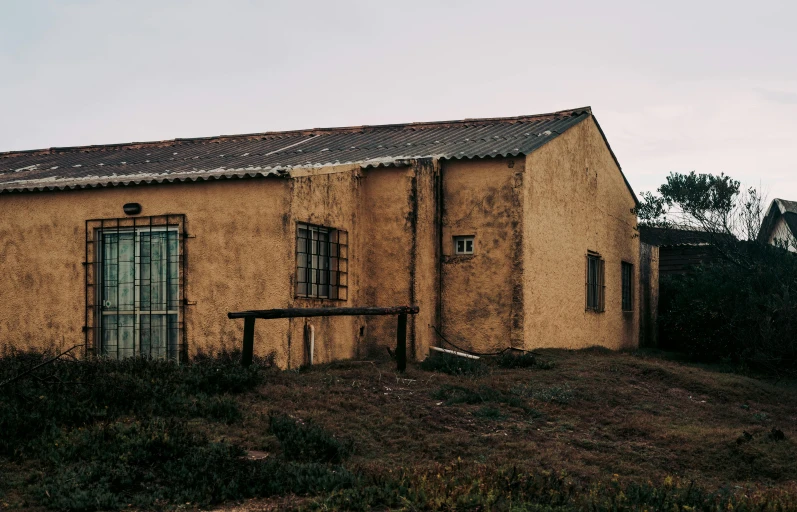 an old, run down building is shown against a cloudy sky