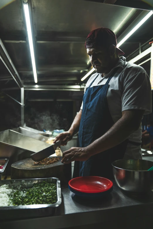 a man in an industrial kitchen chops food