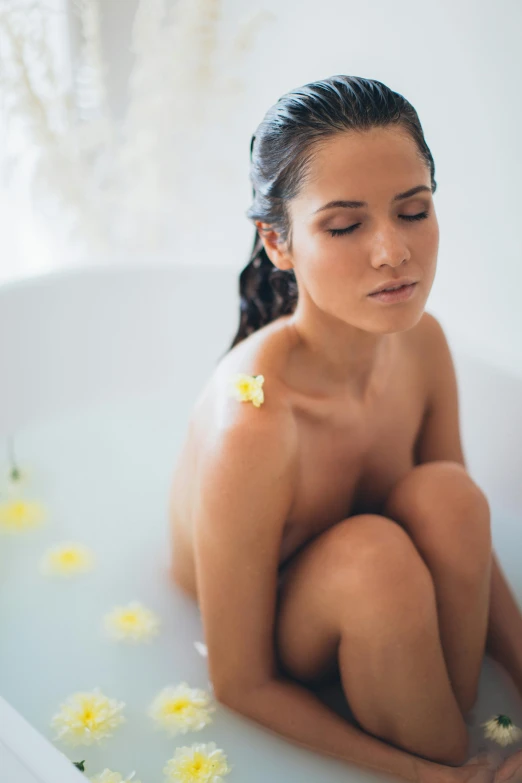 a  girl sitting in a bathtub with flowers