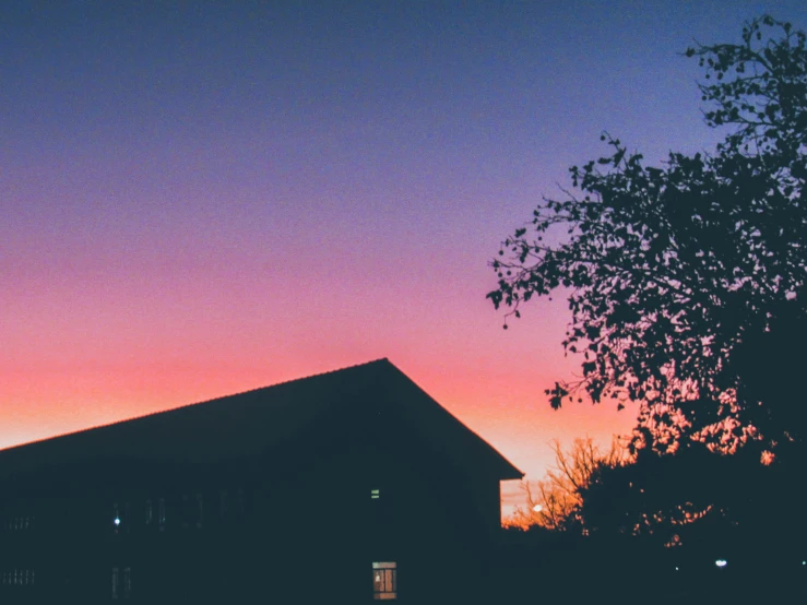this is a view of the sunset on a farm house