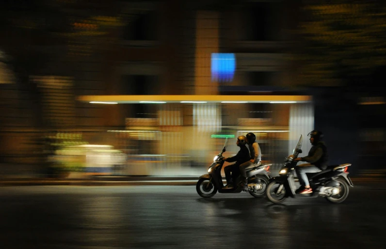 two people are riding motor bikes on the street