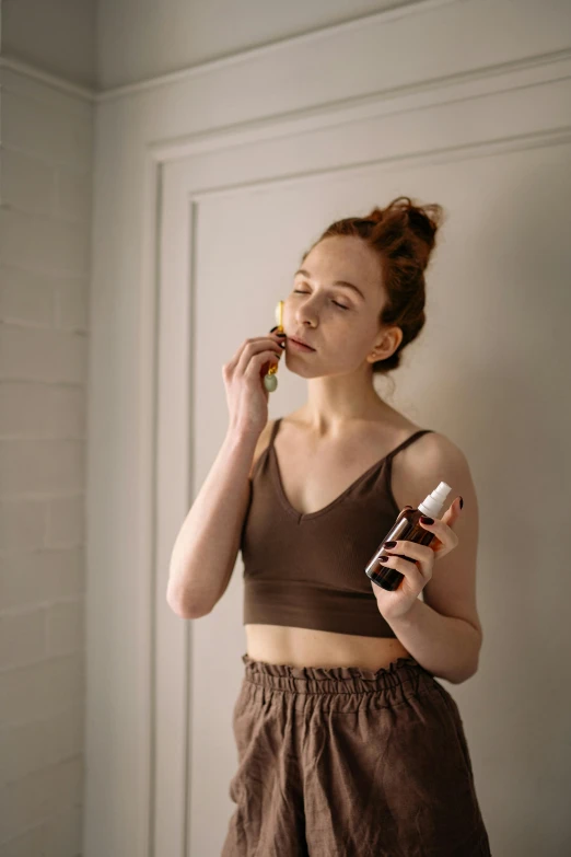 a woman in brown is brushing her teeth