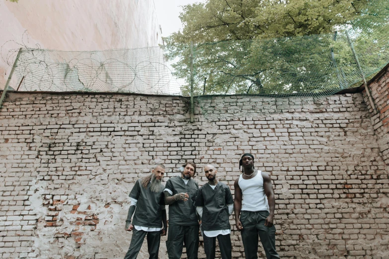 a group of people standing next to a brick wall