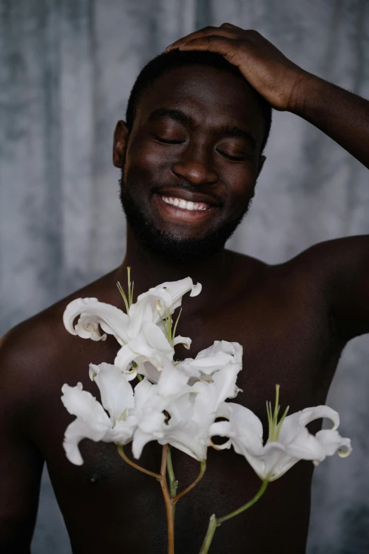 the man is smiling and holding a flower in his hand