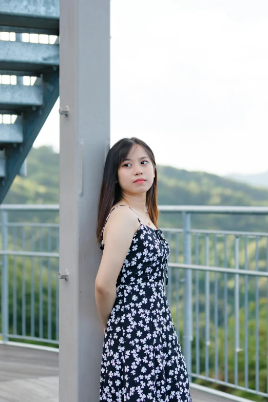 a beautiful woman standing by a metal stair way