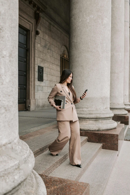 woman standing on steps, with a cell phone in her hand