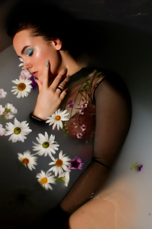 a woman posing for a po in the bathtub with daisies