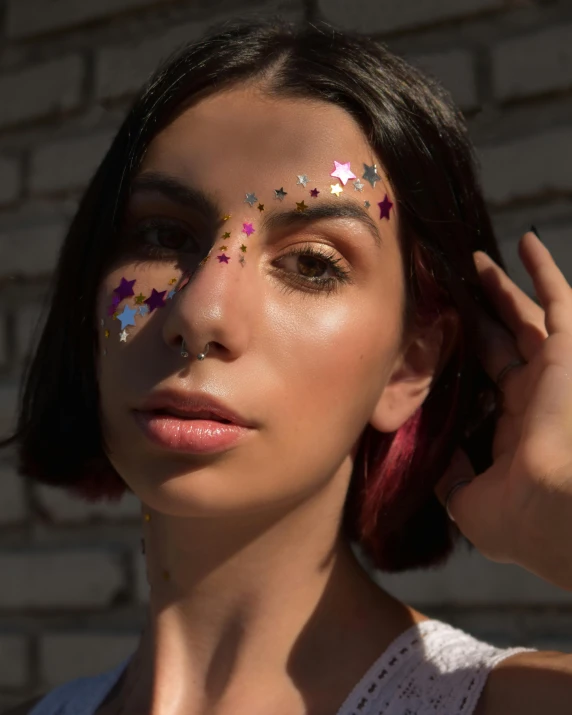 a young woman with colorful face and stars painted on her cheeks