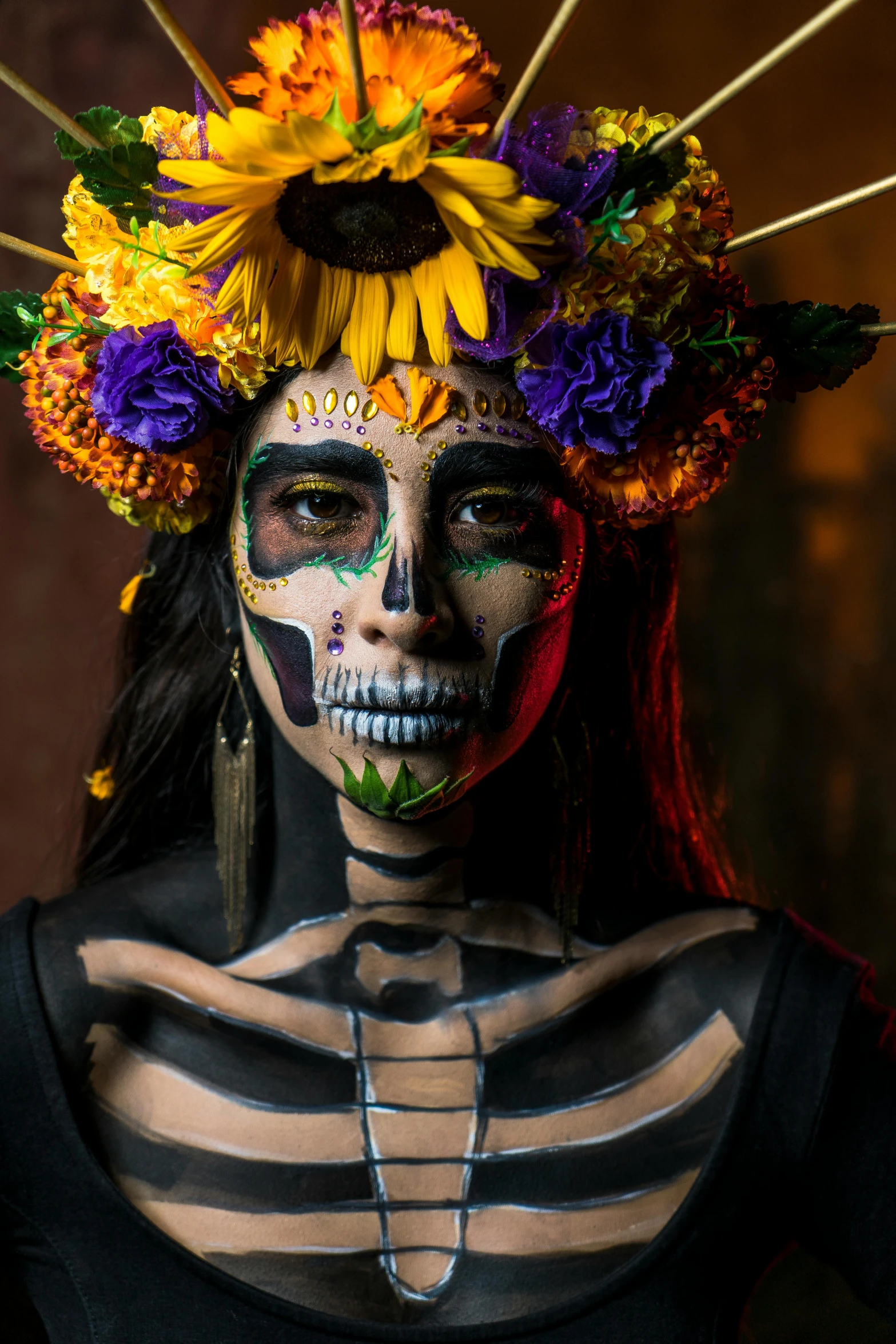 a woman in a skeleton painted dress and a sunflower