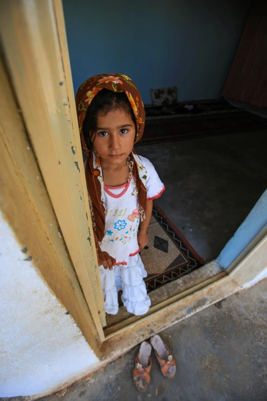 a small girl standing on the doorstep of her home