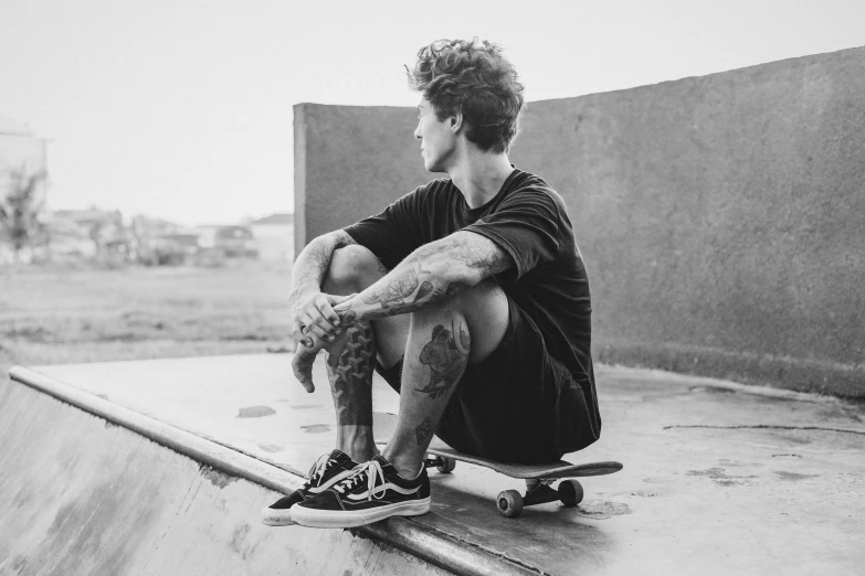 a skateboarder sits in the middle of a halfpipe