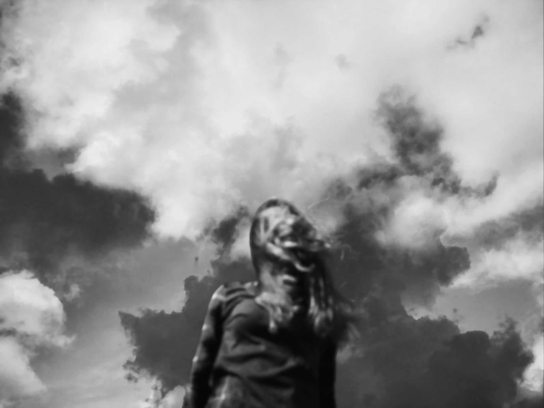a young woman standing under the cloudy sky