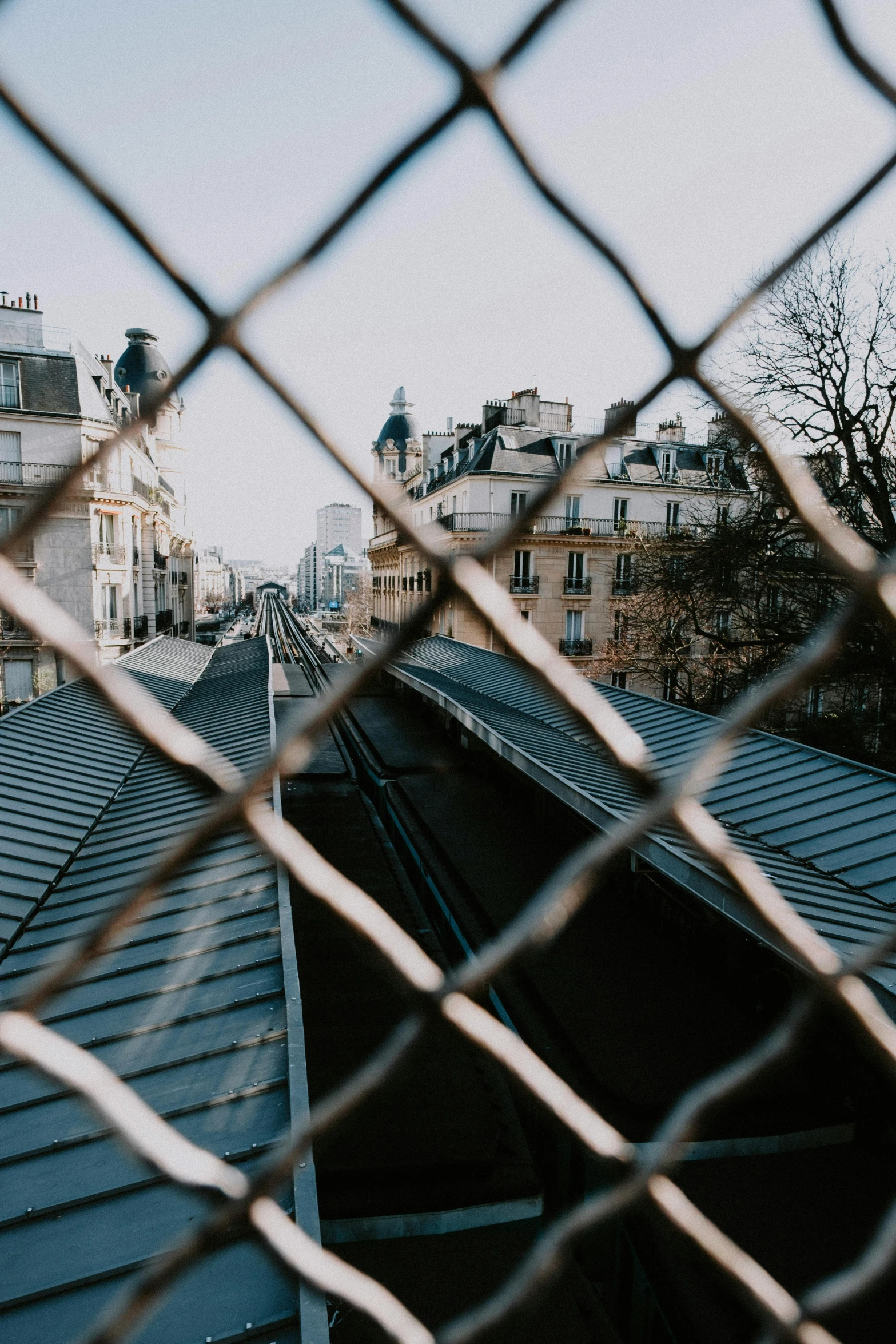 rooftop of houses viewed through wire fence