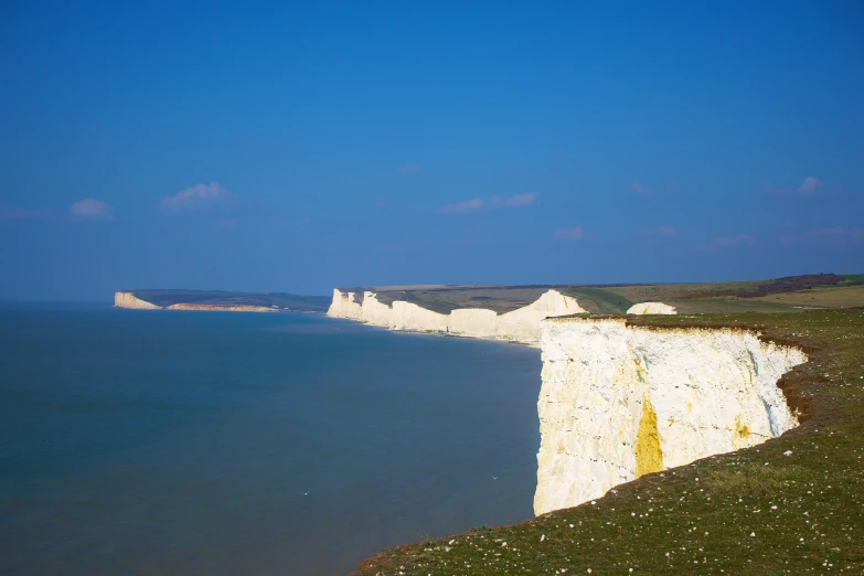 an area near the ocean with a white cliff that is painted into blue and white