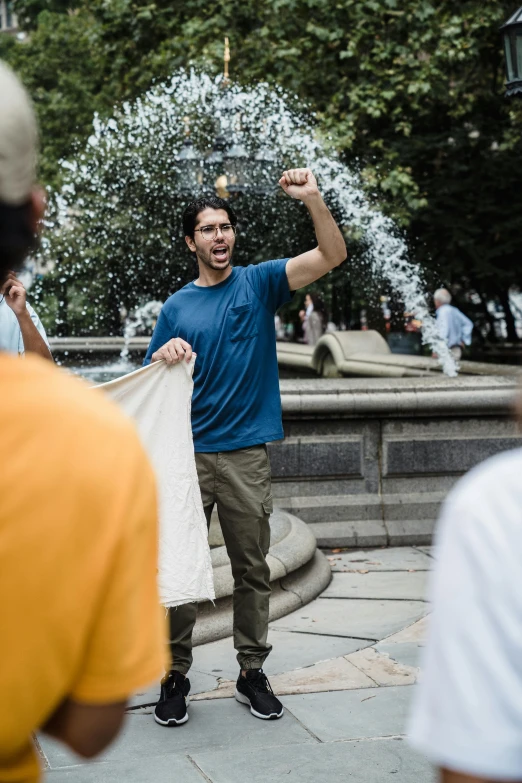 man standing in front of fountain, throwing out water