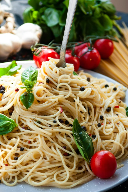 pasta salad with tomatoes and basil on white plate