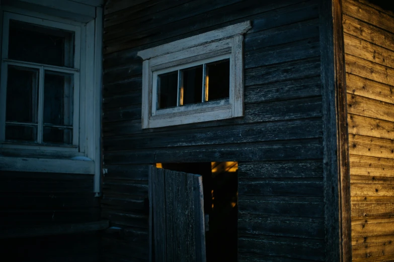 an open door into a wooden building with lots of windows