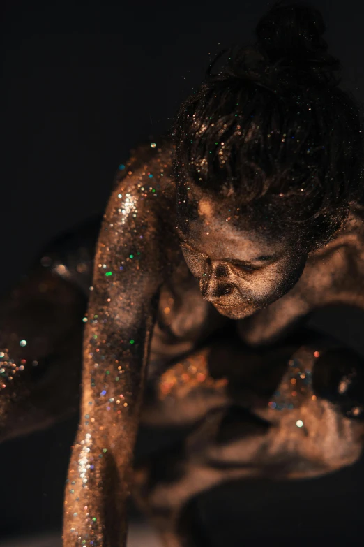 a woman covered with glitters and holding her hands