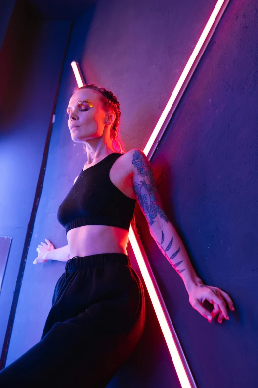 a young woman leaning against a wall with neon lights