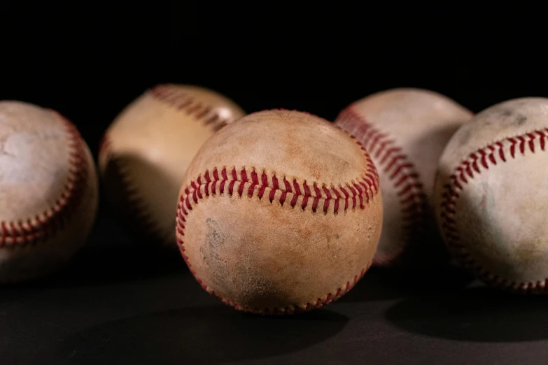 five baseballs are laying on the floor, including one in the middle and the other out